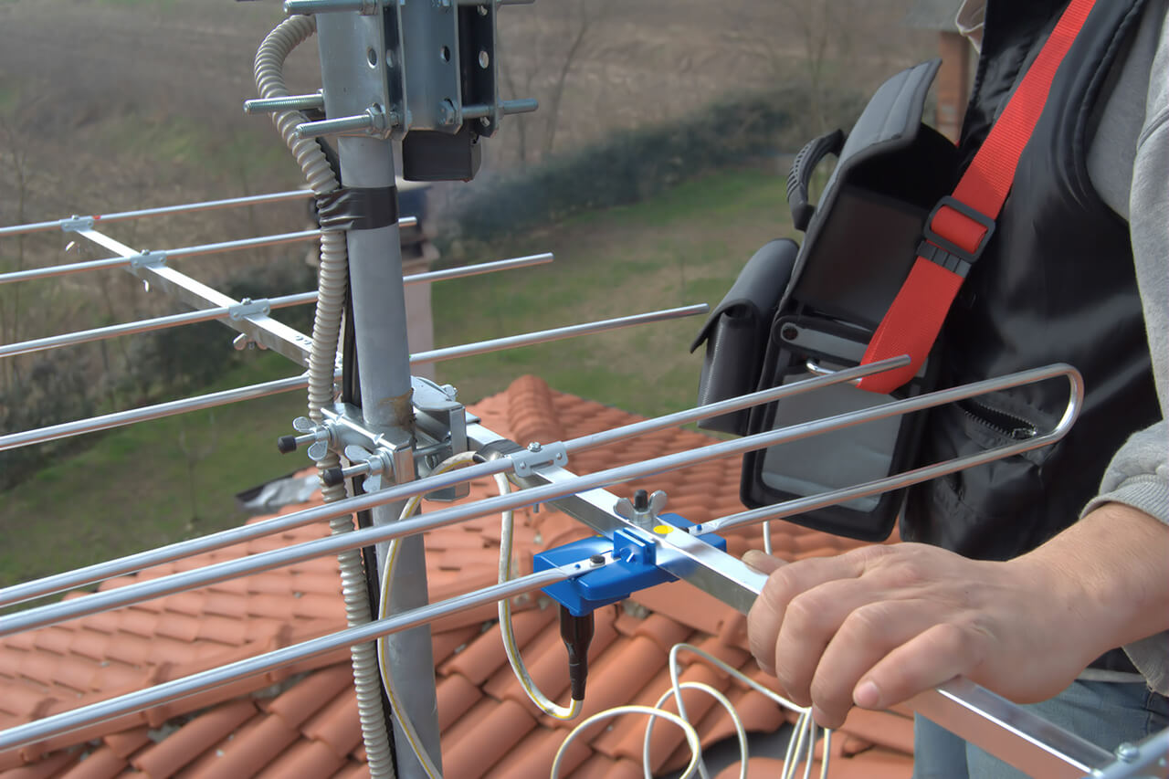 professional installing a tv antenna on roof of house