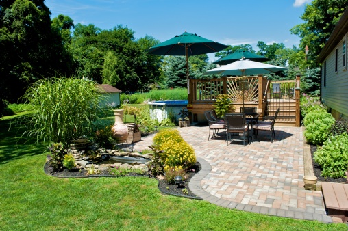 Sunny backyard with brick patio and a pond