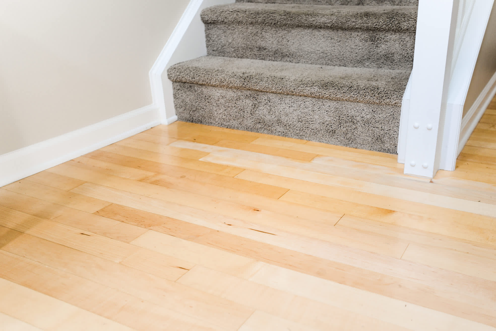 hardwood floor at bottom of carpeted stairs