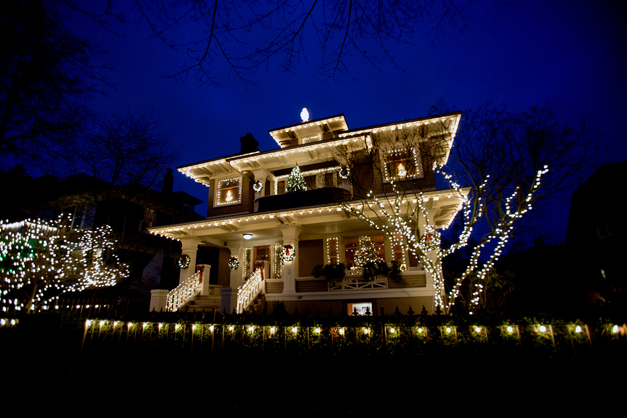 Home at night with holiday lights on house and trees