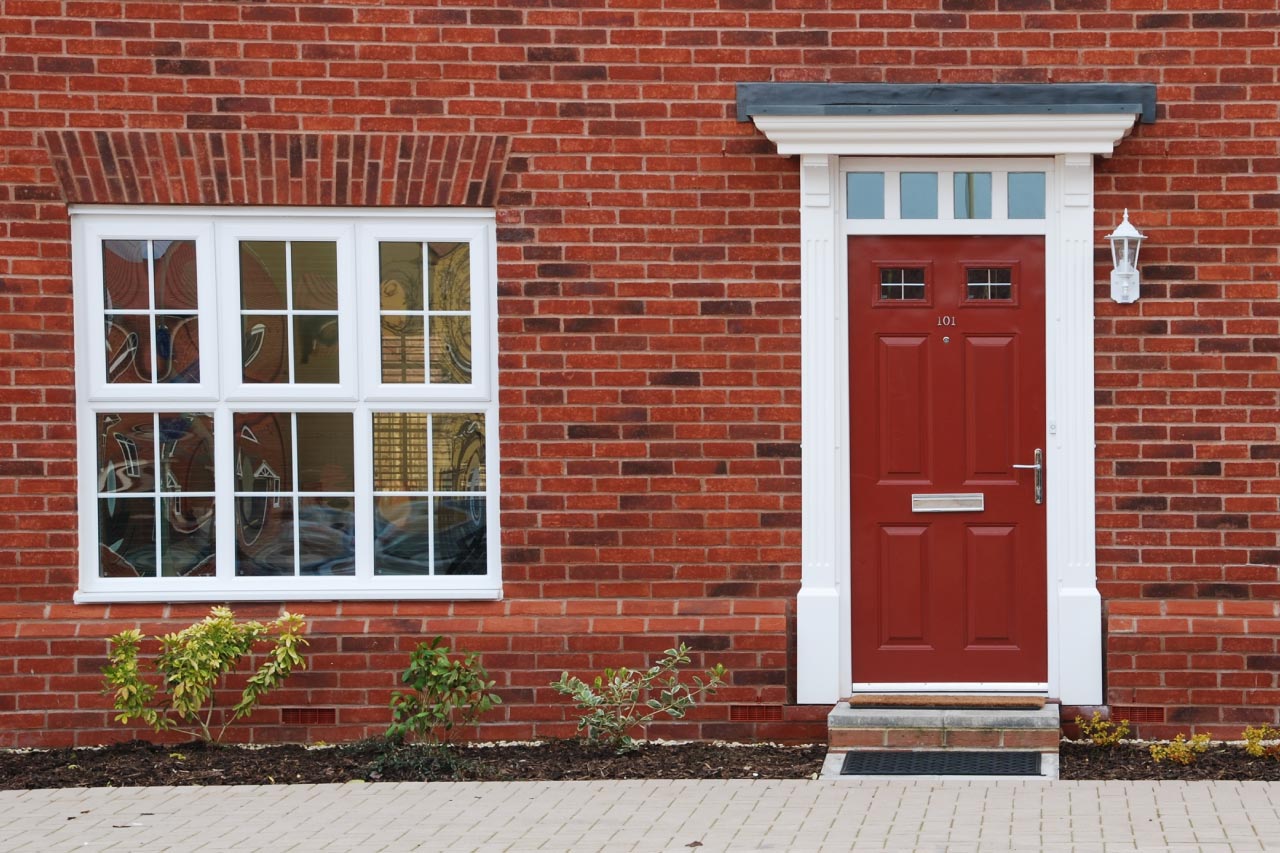 House with red front door and red brick wall
