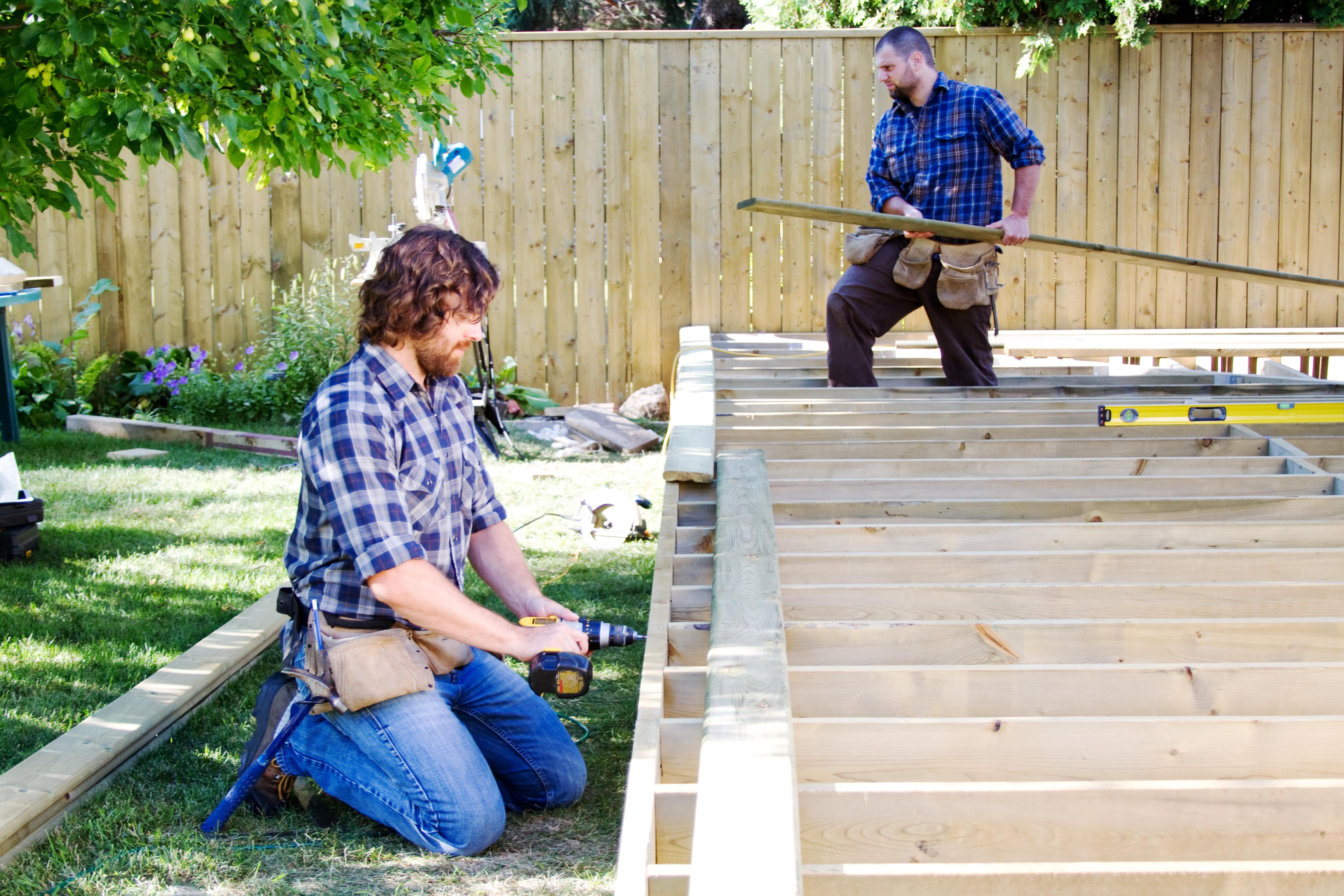Two men building a wood deck
