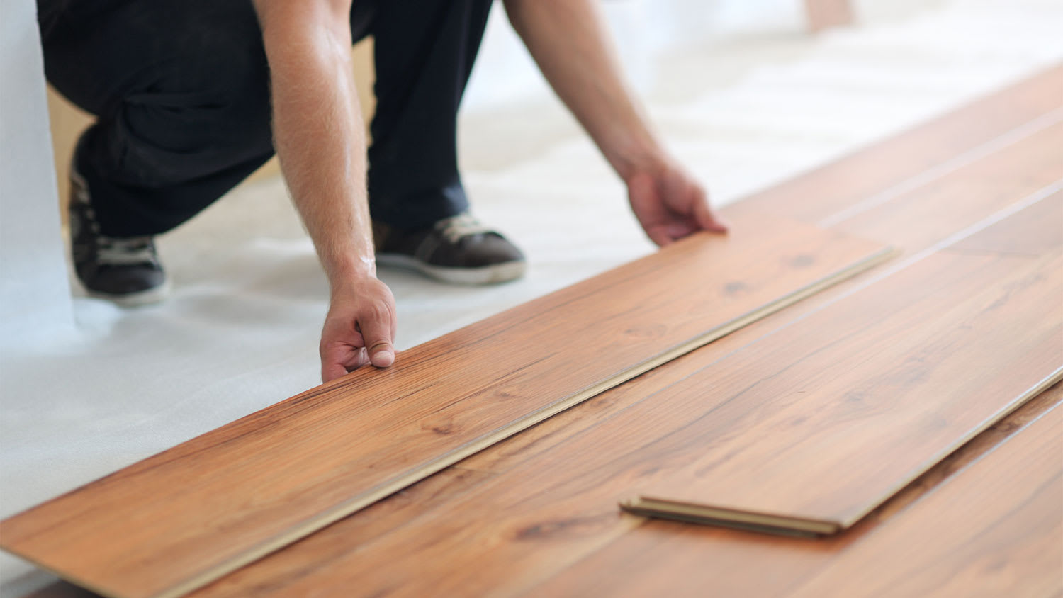 man installing laminate wood floor