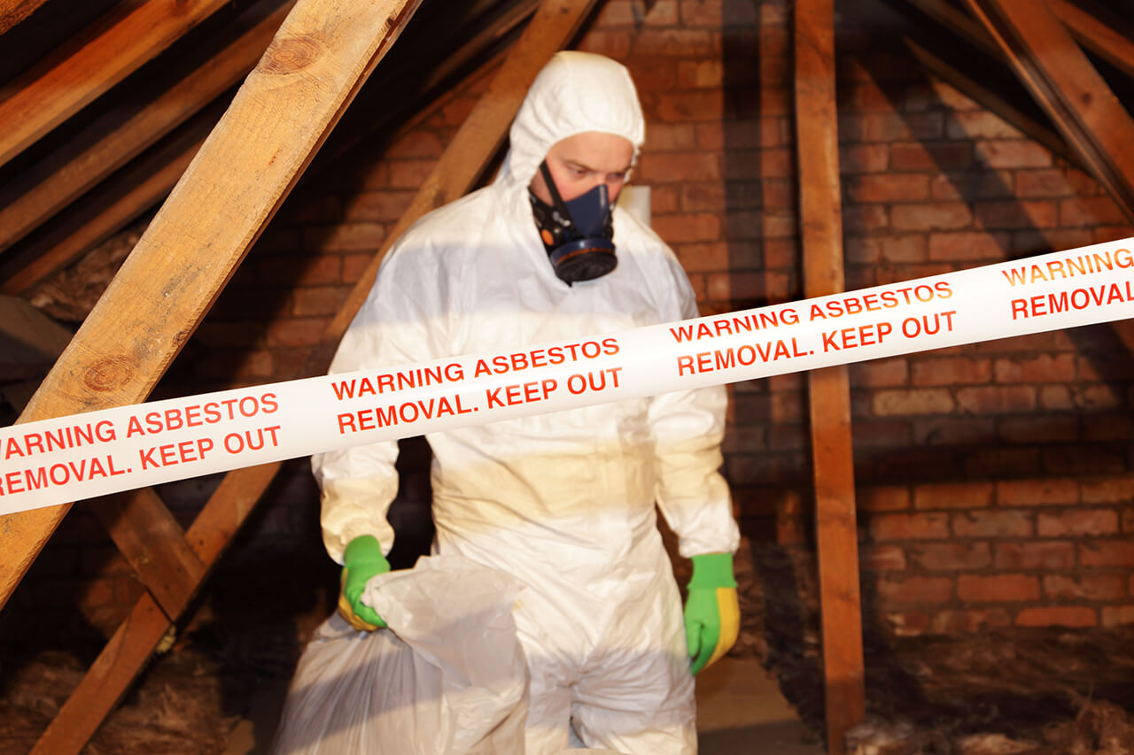 professional in protective suit removing asbestos from attic of home