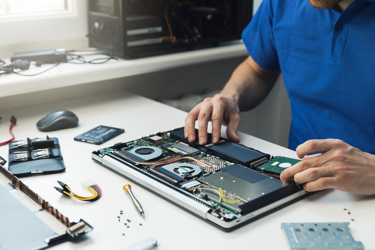 A repairman installing new hard disk drive in laptop